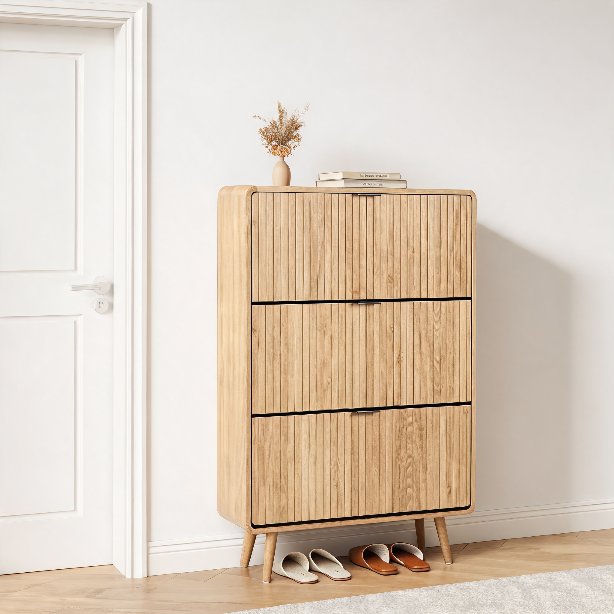 Natural oak slim shoe cabinet beside a white door with slippers underneath