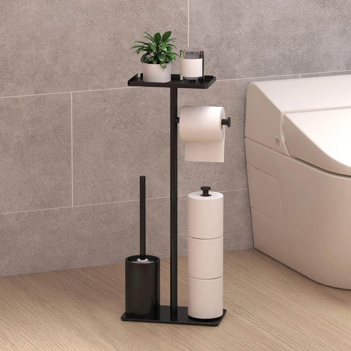 Black freestanding toilet paper stand with shelf beside a toilet