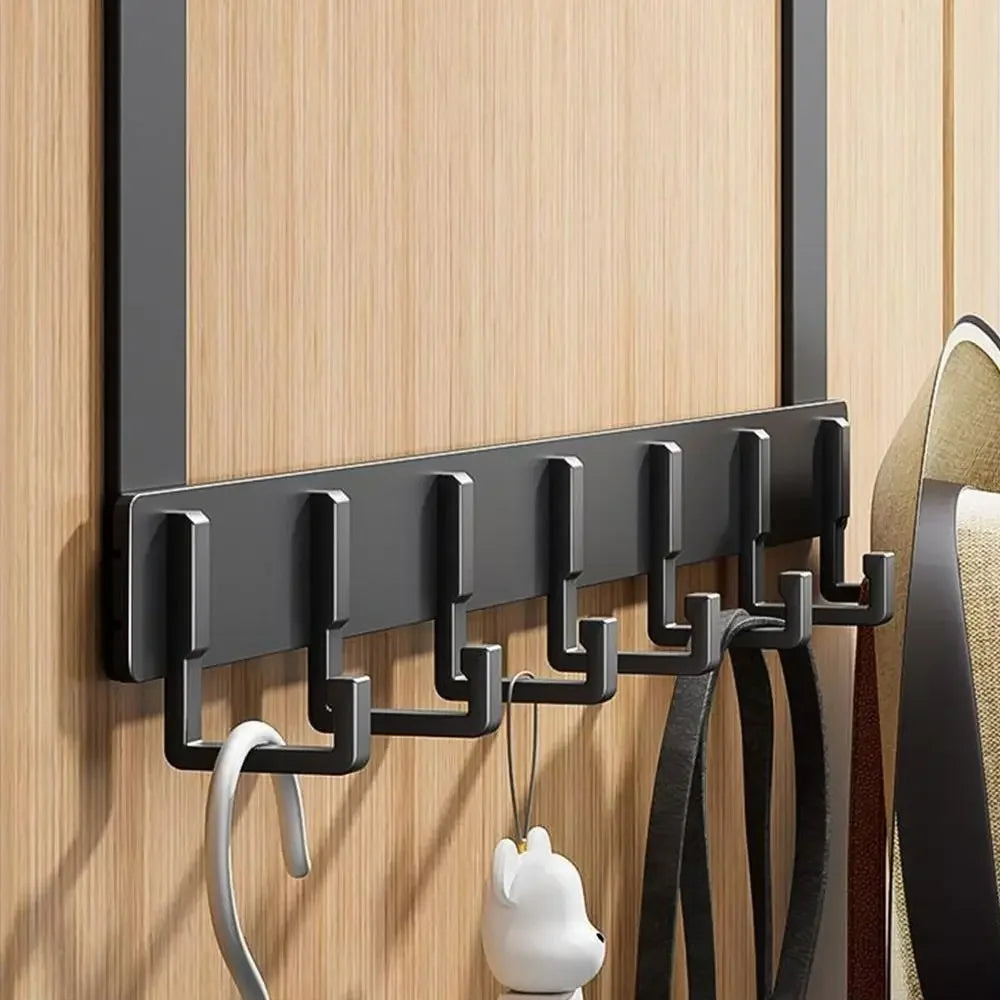 Black over-the-door hook rack on a wooden door