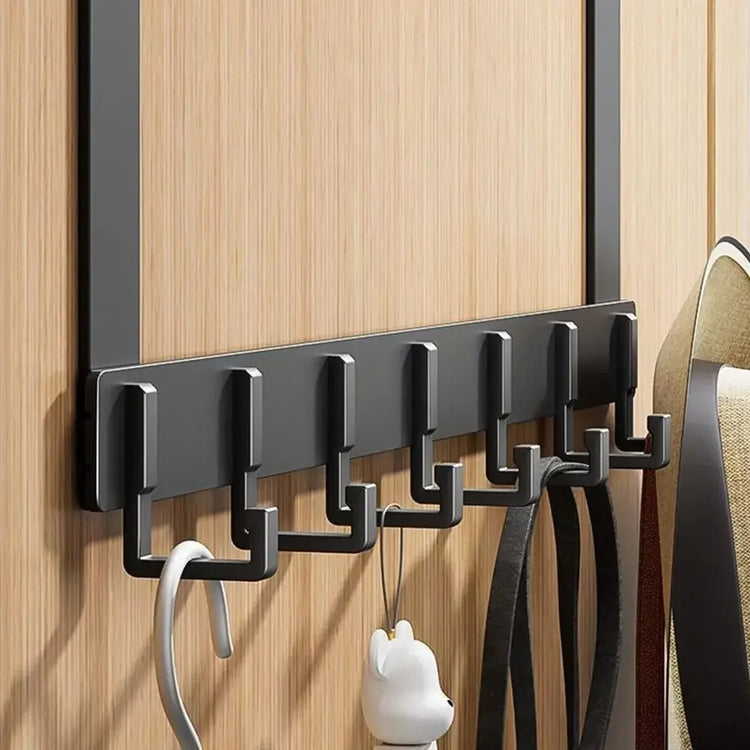 Black over-the-door hook rack on a wooden door