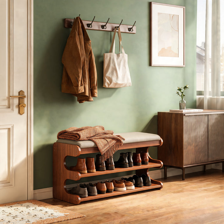 Shoe storage bench with shoes on two shelves in a sage green hallway