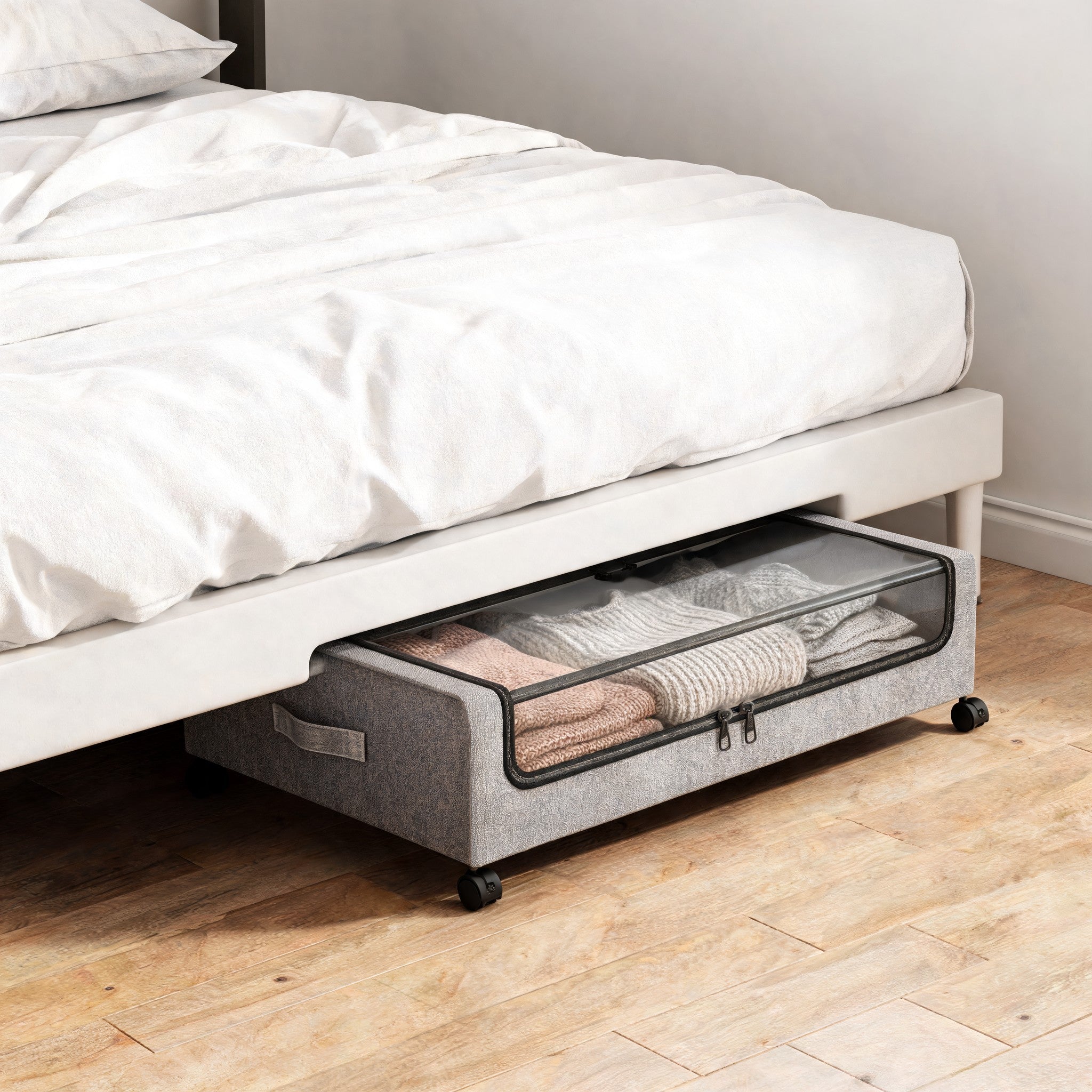 Rolling underbed storage container with clear lid pulled out from under a bed