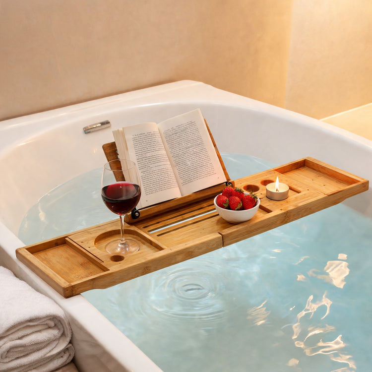 Bamboo bathtub caddy tray with book, wine and candle across a bathtub