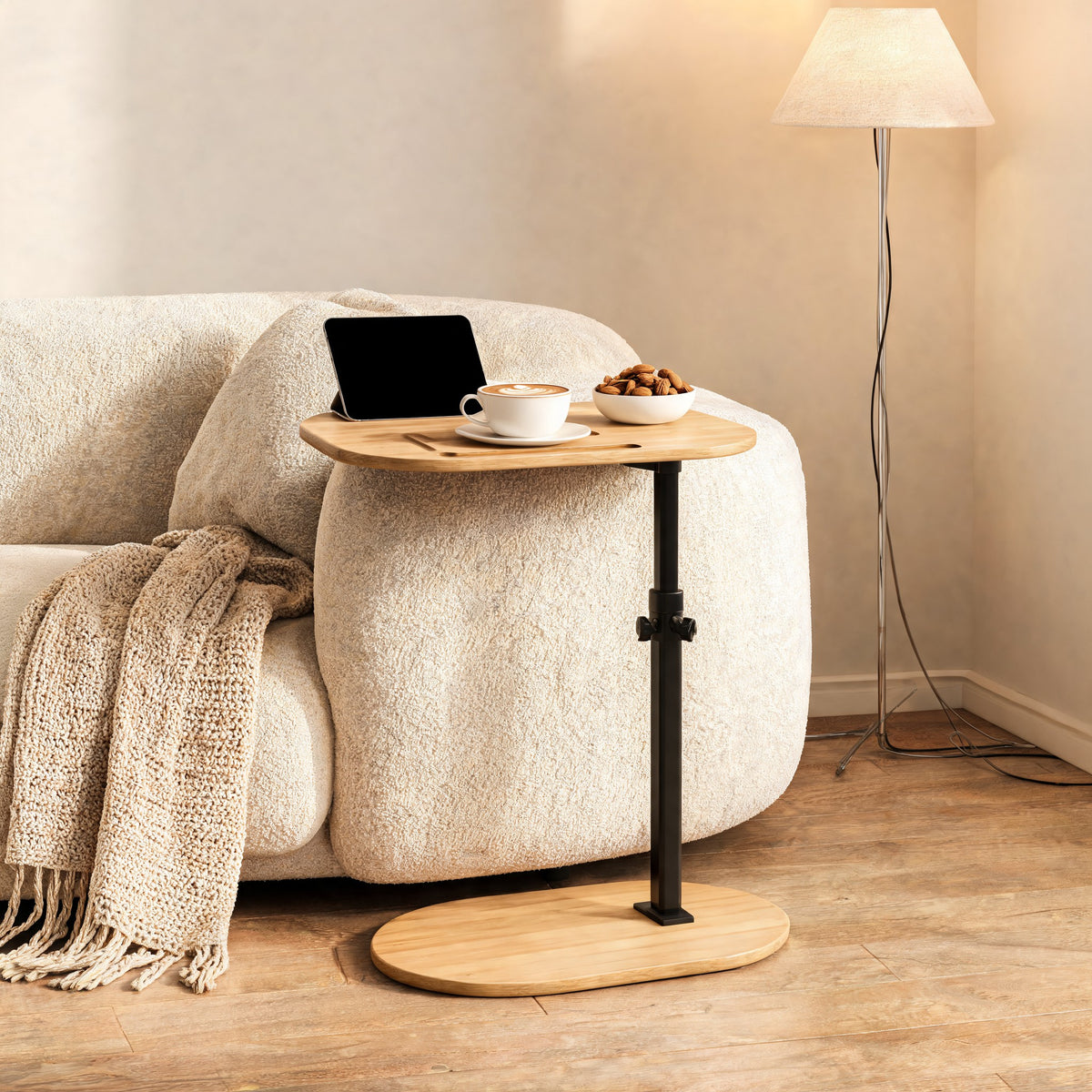 Adjustable side table with tablet and coffee beside a sofa